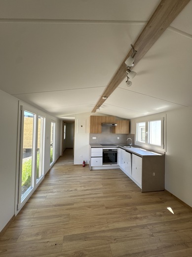 spacious-living-room-of-mobile-home-with-kitchen.JPG